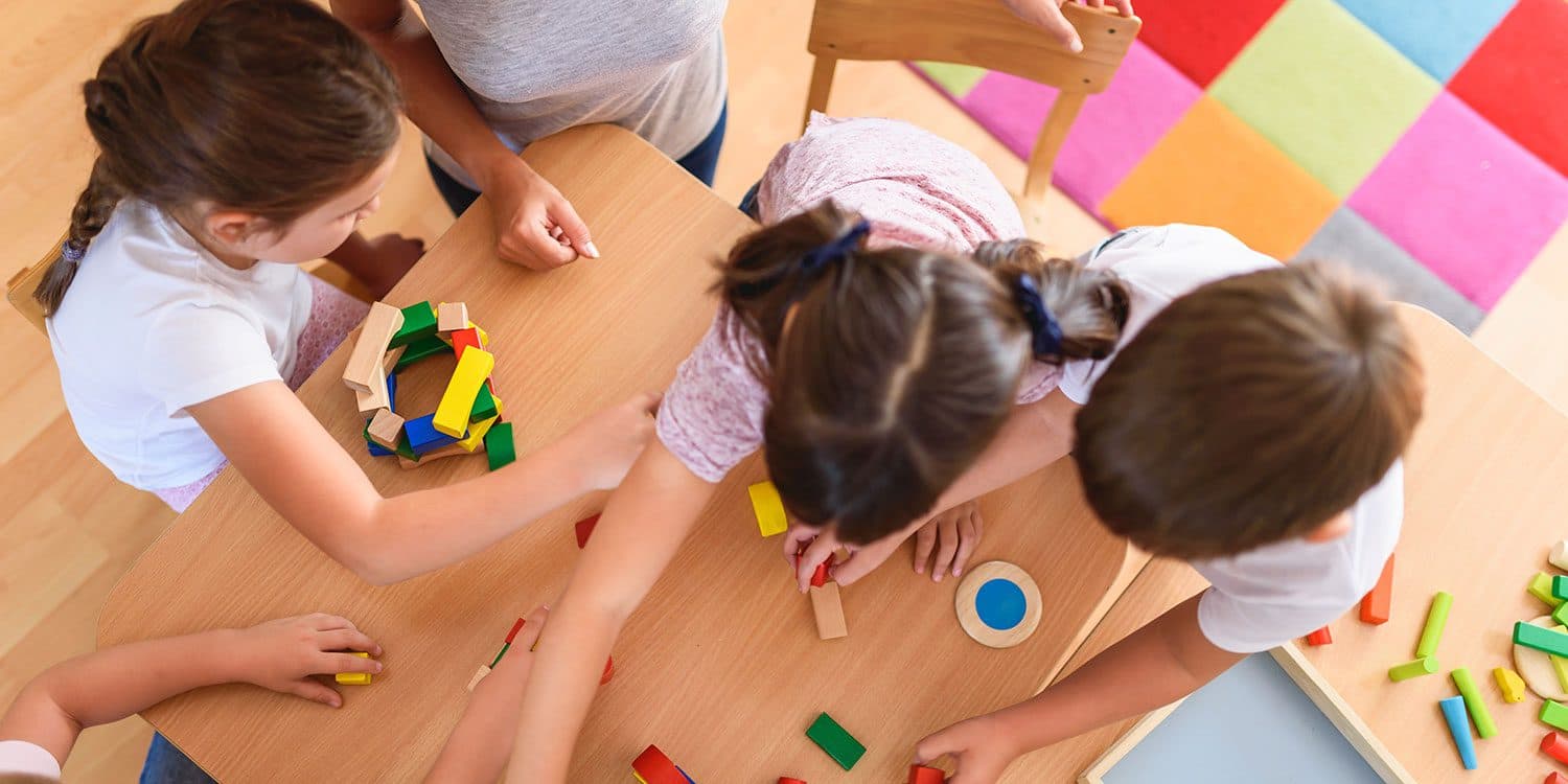 Children building with blocks at a classroom table