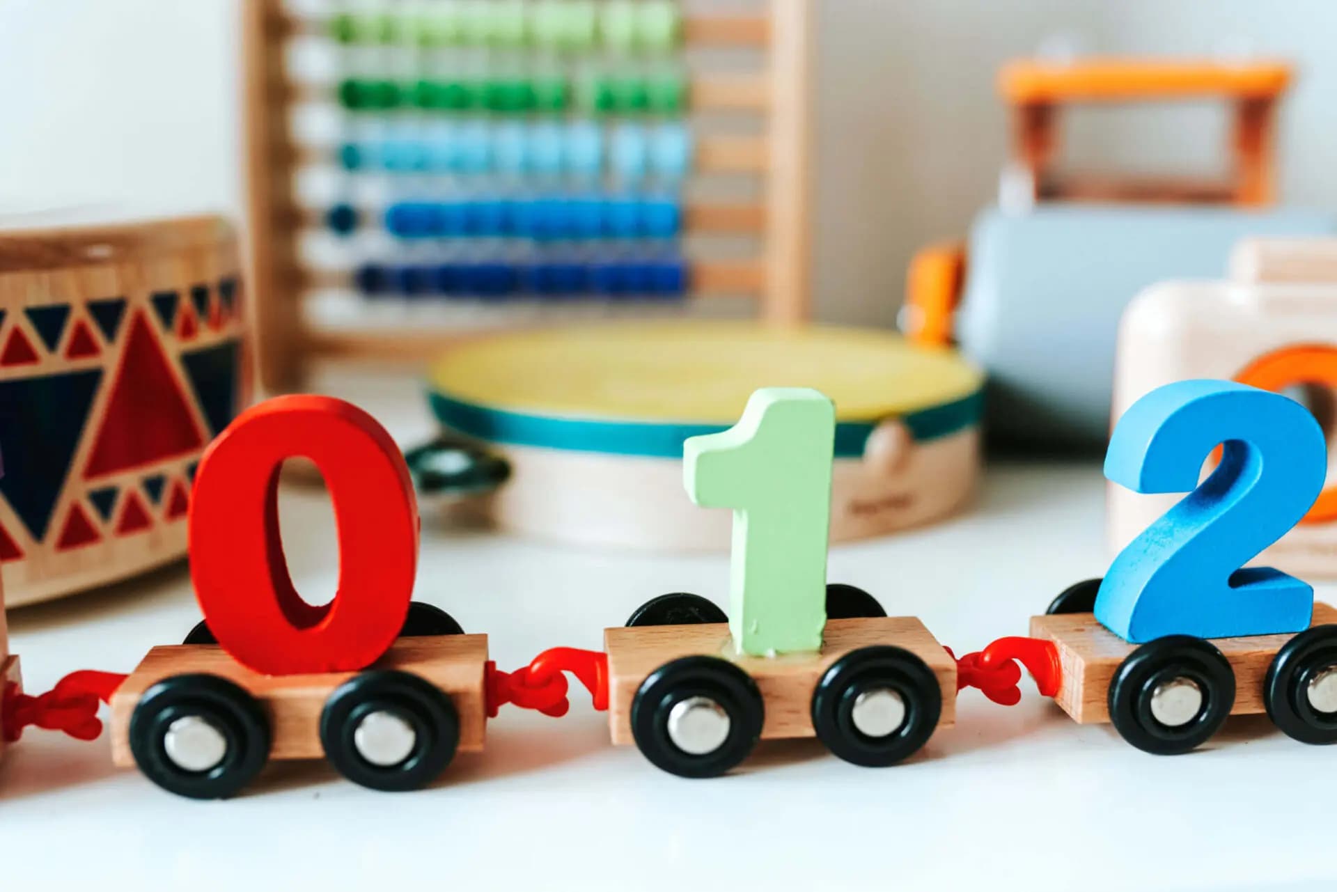 Wooden toy train carrying the numbers 0, 1, and 2 in a classroom