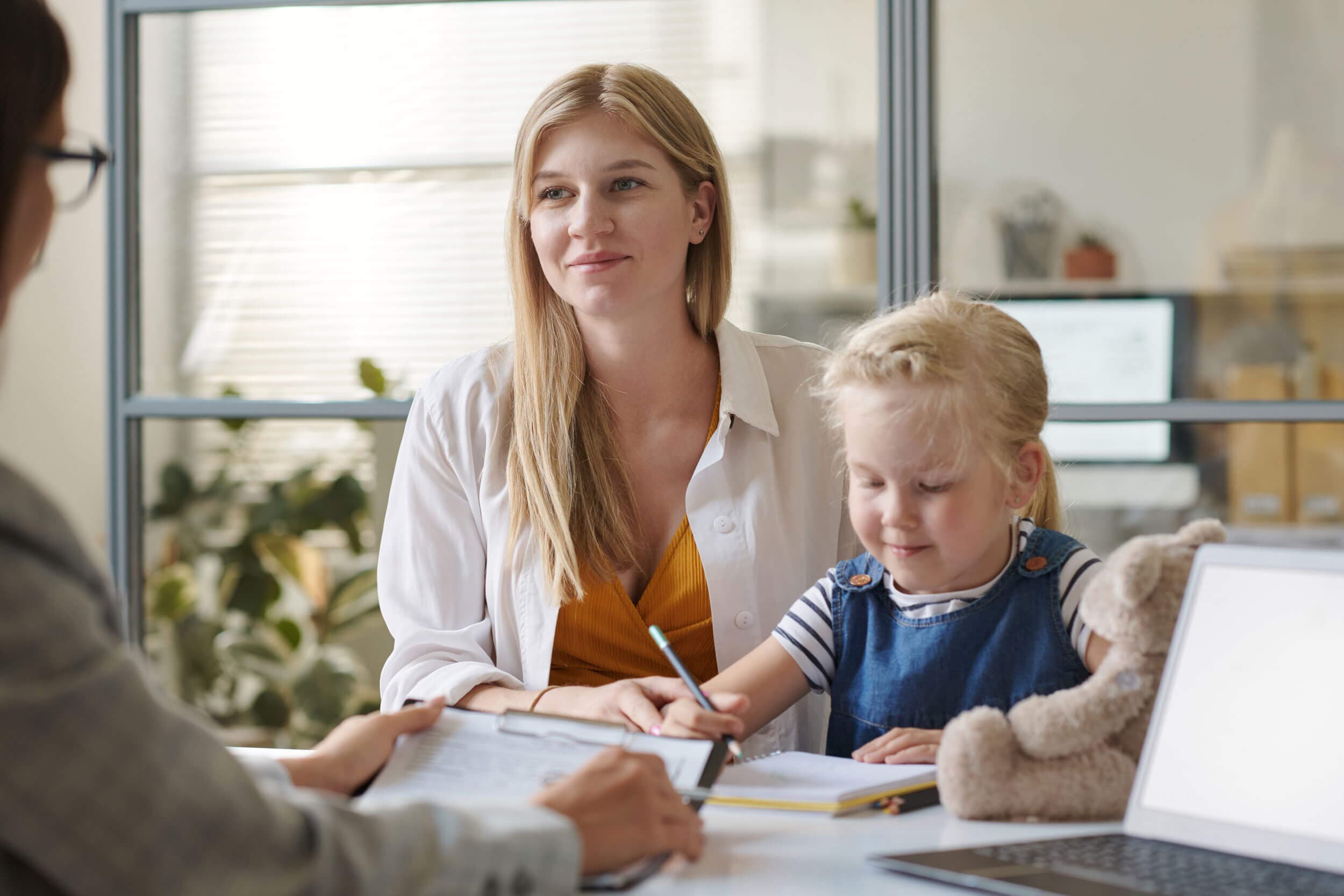 A parent and child reviewing the child's progress with a teacher
